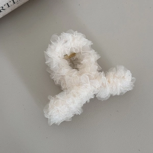 Gros plan sur une pince à cheveux en tulle blanc multicouche à la texture vaporeuse