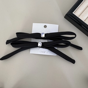 Detail of black satin bow hair clips with rectangle rhinestones on display card