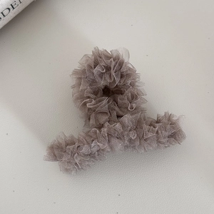 Vue détaillée d'une pince à cheveux en tulle taupe avec texture plissée élégante