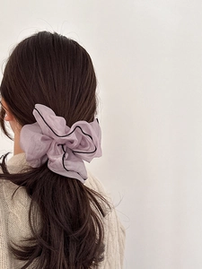 Elegant purple organza scrunchie with black trim shown on a low ponytail hairstyle