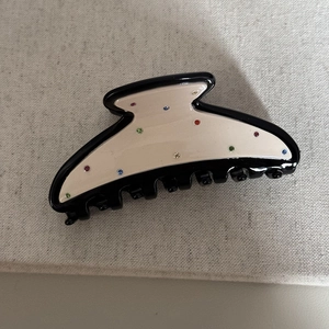 Dettaglio della molletta per capelli in acetato con strass colorati in nero e bianco