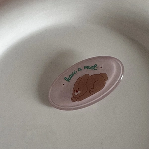 Vue macro d'une barrette ovale en résine mauve avec un motif de lapin de dessin animé