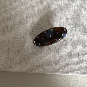 Dettaglio del fermaglio per capelli ovale a guscio di tartaruga con strass colorati su stoffa