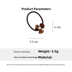Detail of tortoiseshell flower hair tie with pearl center, measuring 5.5cm x 6cm