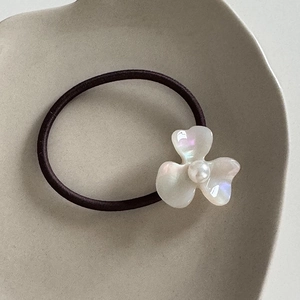 Detail of French vintage acetate flower hair tie with pearl center and brown elastic band