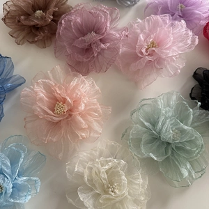 Détail des pinces à cheveux orchidée en mousseline avec des couleurs pastel variées