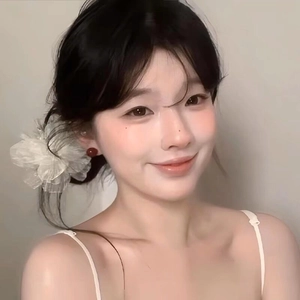 Détail d'un chouchou floral en mousseline blanche et de boucles d'oreilles rouges sur modèle