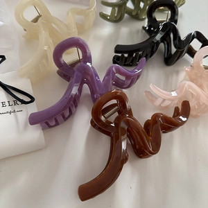 Minimalist large wavy hair claws in assorted colors for thick hair on white background