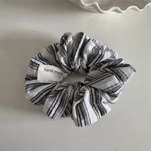 Detail of hand made label on a striped fabric scrunchie with soft cotton texture