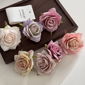 Elegant multi-color velvet rose hair clips in vintage shades on a minimalist wooden tray