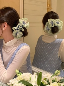 Détail d'un chouchou à carreaux vert menthe avec bordure en dentelle sur un modèle