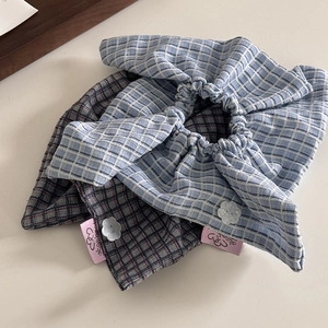 Detail of plaid fabric hair scrunchies with decorative buttons and cotton texture