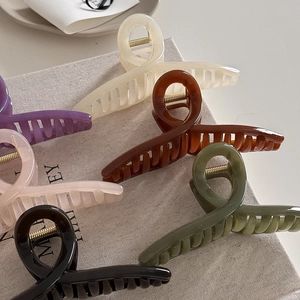 Minimalist resin hair claw clips set in six assorted colors with a textured book background