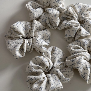 Detailed texture of blue floral fabric scrunchies in pleated cotton linen material