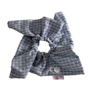 Blue checkered fabric scrunchie with floral button and bloom label for low ponytail hairstyles