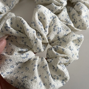 Floral print hair scrunchie with blue micro flowers on beige fabric for hair styling