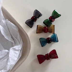 Close-up of five colorful resin bow hair clips with gold France Handmade lettering