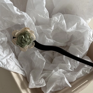 Detail of a vintage Chinese camellia hair pin with handcrafted green and white fabric petals