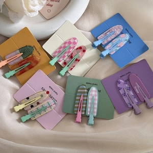 Set of fruit themed hair clips including cherry and grape patterns on silk background