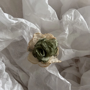 Detailed macro view of camellia hair stick showing white lace petals and green satin core