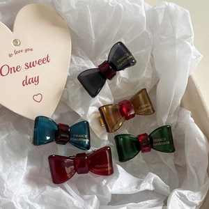 Close-up of five colorful bow hair clips on white paper with France Handmade text