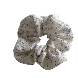Floral print hair scrunchie in beige with blue flower pattern for elegant hair styling