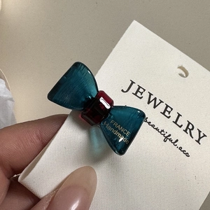 Detailed close-up of handmade blue bow hair clip with gold France Handmade lettering