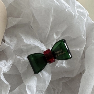Detail of the handmade green acetate bow hair clip showing the France Handmade text engraving