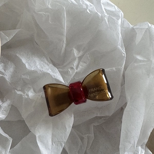 Detailed close-up of handmade amber resin bow clip with France Handmade engraving