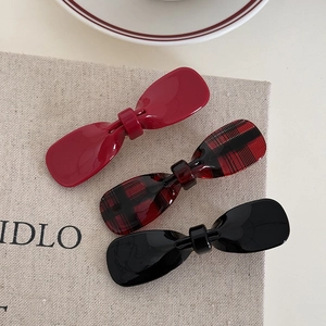 Three-piece acetate bow hair clips set in burgundy, black, and checkered pattern textures