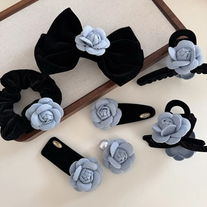 Elegantes Set aus schwarzen Samt-Haarspangen mit hellblauen Stoff-Kamelienblüten