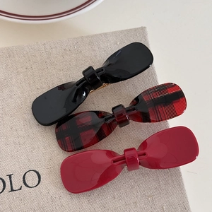 Three-piece acetate bow hair clip set featuring black, plaid, and deep red glossy finishes