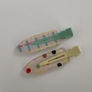 Detail of glitter checkered and polka dot hair clips with colorful duckbill metal clamps