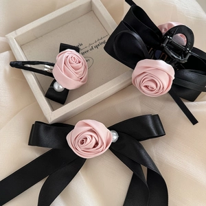 Elegant rose hair claw clip set with silk ribbons and pearls on a beige fabric background