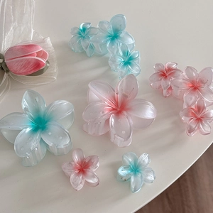 Pinces à cheveux fleurs de frangipanier dégradées bleu et rose pour coiffures de plage