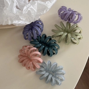 Set di elastici per capelli a spirale in vari colori pastello su una superficie bianca