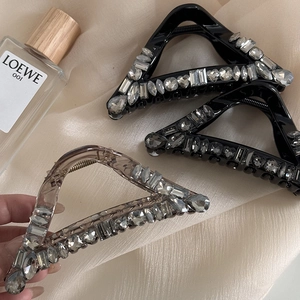 Close-up of luxury triangular hair claw clips with shimmering rhinestones on silk