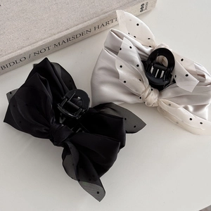 Elegant bow hair claws in black and cream with polka dot mesh layers and 45-degree view