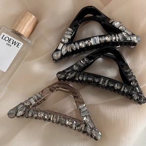 Sparkling rhinestone hair claw clips in triangular shape with elegant silk background