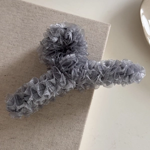 Détail d'une grande pince à cheveux en organza plissé gris au design nuage élégant
