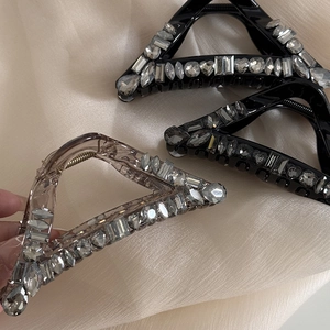Sparkling rhinestone triangle hair claws in black and amber colors on silk