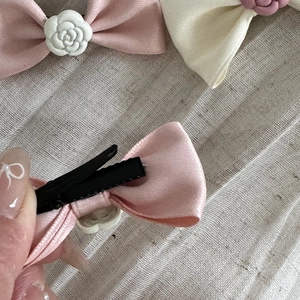 Dettaglio di fermagli per capelli a fiocco con camelia e clip a becco d'anatra in metallo