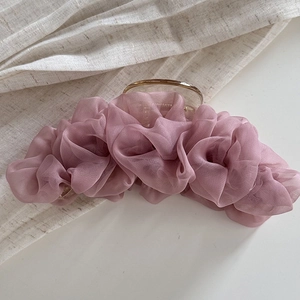 Detail van elegante geplooide haarklem van mesh in mauve met een gouden metalen sluiting