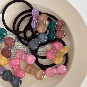 Multi-color jelly bow hair ties set made of acrylic and elastic band in a ceramic dish