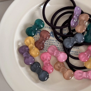 Macro detail of various colorful jelly bow hair clips with elastic black hair bands