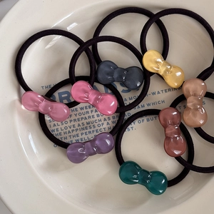 Set of 8 colorful jelly bow hair ties with transparent resin charms on white plate
