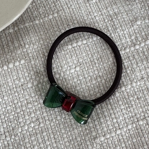 Detail eines dunkelgrünen Harz-Haargummis mit goldener France Handmade Prägung
