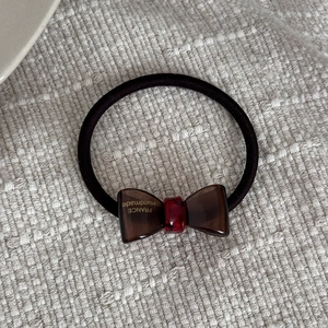 Detail von handgefertigtem Acetat-Bogen-Haargummi mit Frankreich-Gravur und Gummiband