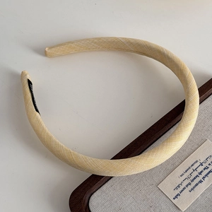 Macro detail of pale yellow twill fabric texture on a slim sponge headband accessory