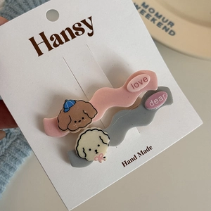 Detail of pink and gray cartoon dog hair clips with wavy texture on display card